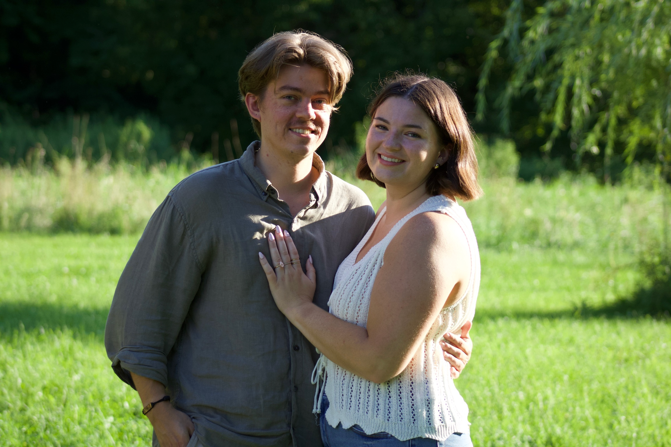 Morgan and Jesse smiling together in a sunlit field