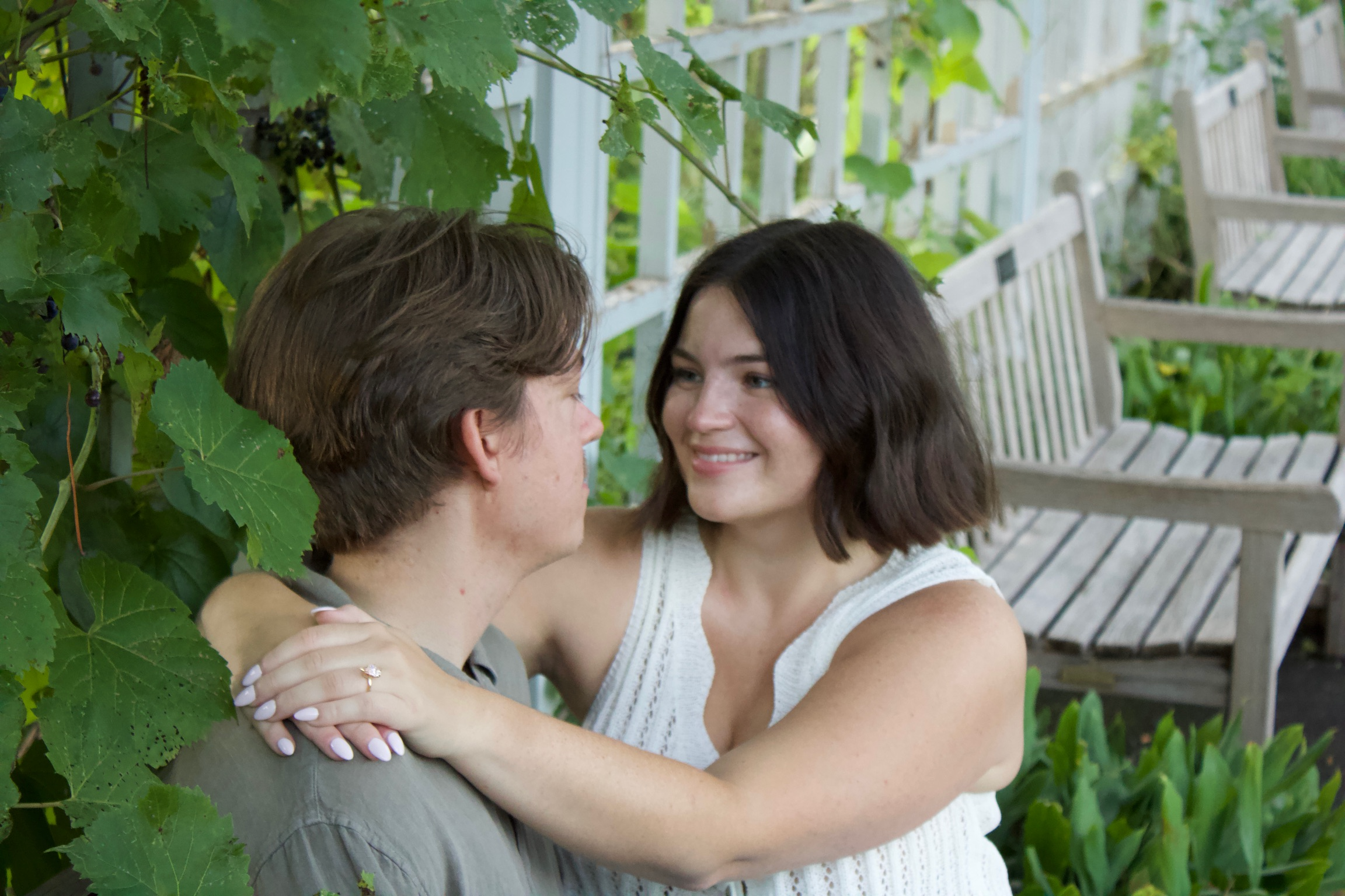 Morgan and Jesse embracing near a rustic fence